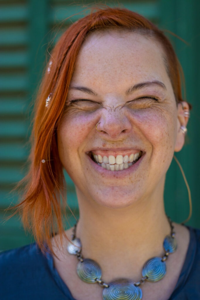 Portrait von Friederike Amara Sonnenberg, die aus vollem Herzen lacht.